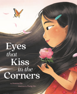 Vertical rectangular book Cover. The title, Eyes that Kiss in the Corners, is on the bottom left side of the cover. The cover shows a young girl in profile looking towards the left side of the book. She has long dark hair that sweeps towards the left side of the cover. She has a small green barrette in it. Her skin is light brown with reddish brown cheeks. She is holding a pink flower in her hand. Her eye (left eye) "kisses in the corners". She is wearing a short sleeved red top or dress. There is an orange and black butterfly in the top left hand side. 